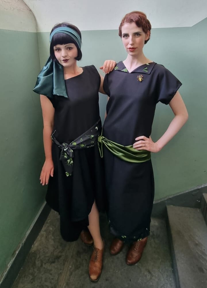 Cast members of Earwig, wearing black and green 1920s dresses, out flyering at Edinburgh Fringe 2022.